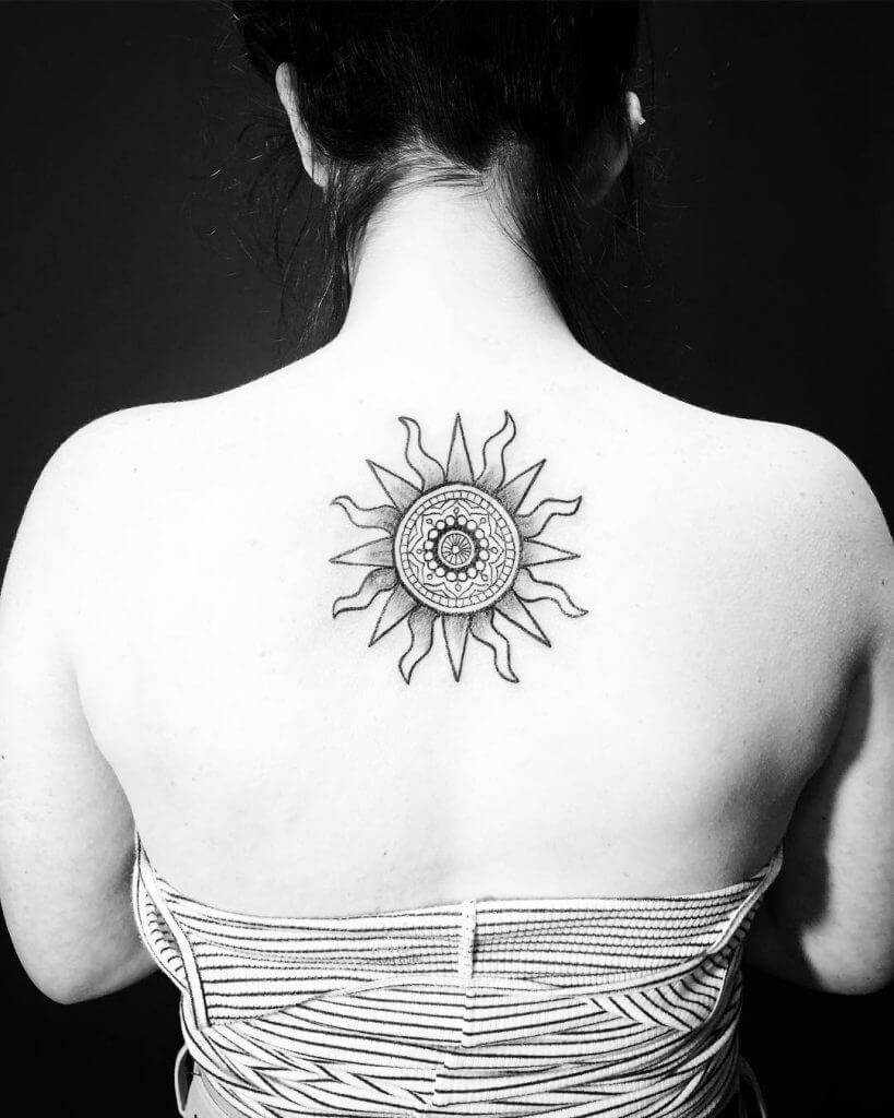 Tribal black sun tattoo on the back