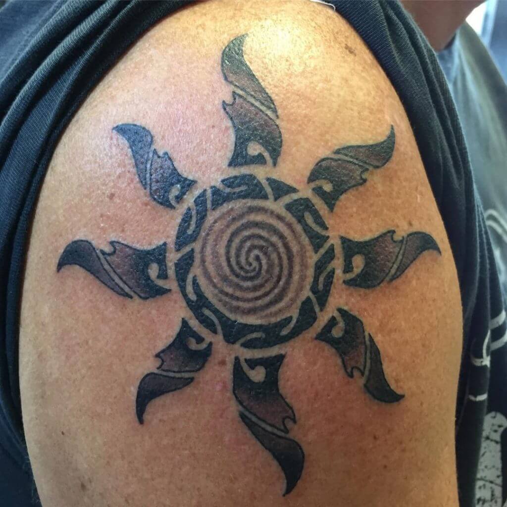 Tribal black sun tattoo on the right shoulder