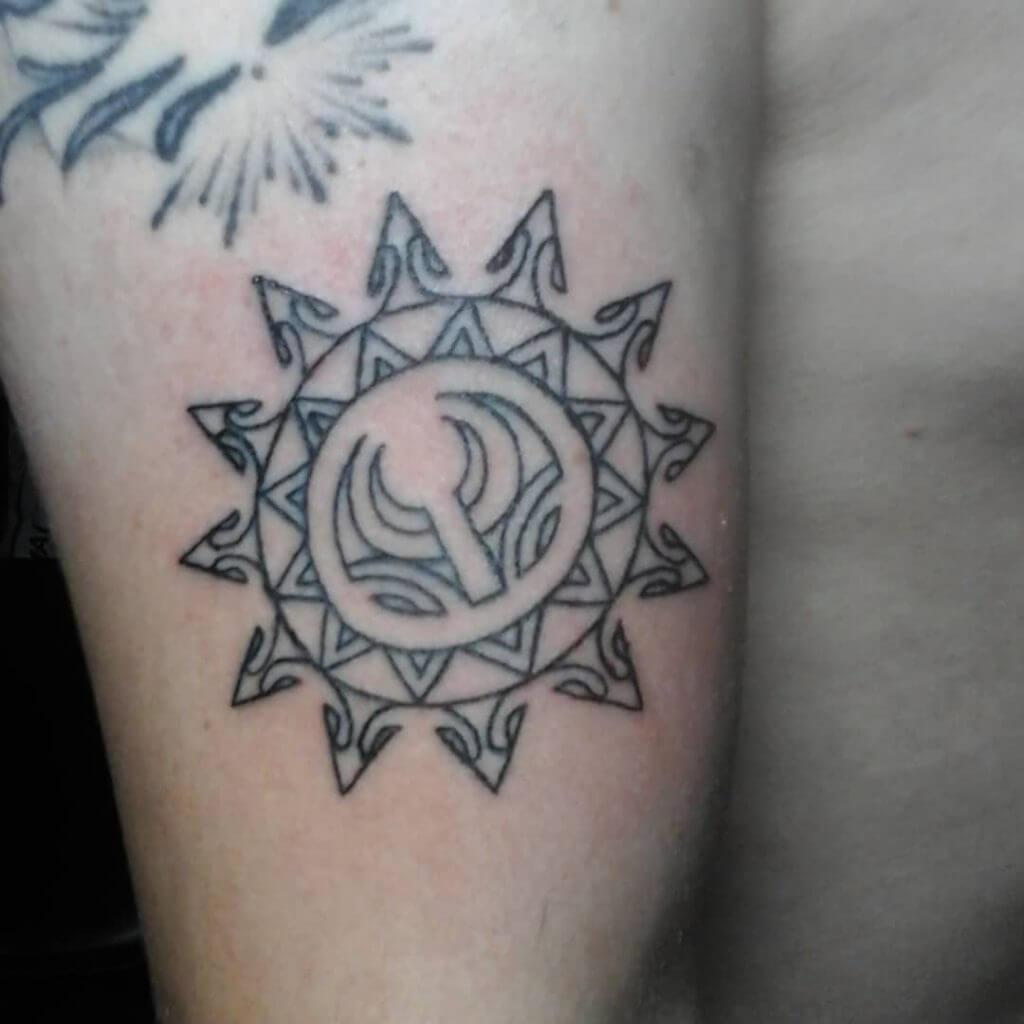 Tribal black sun tattoo on the right thigh