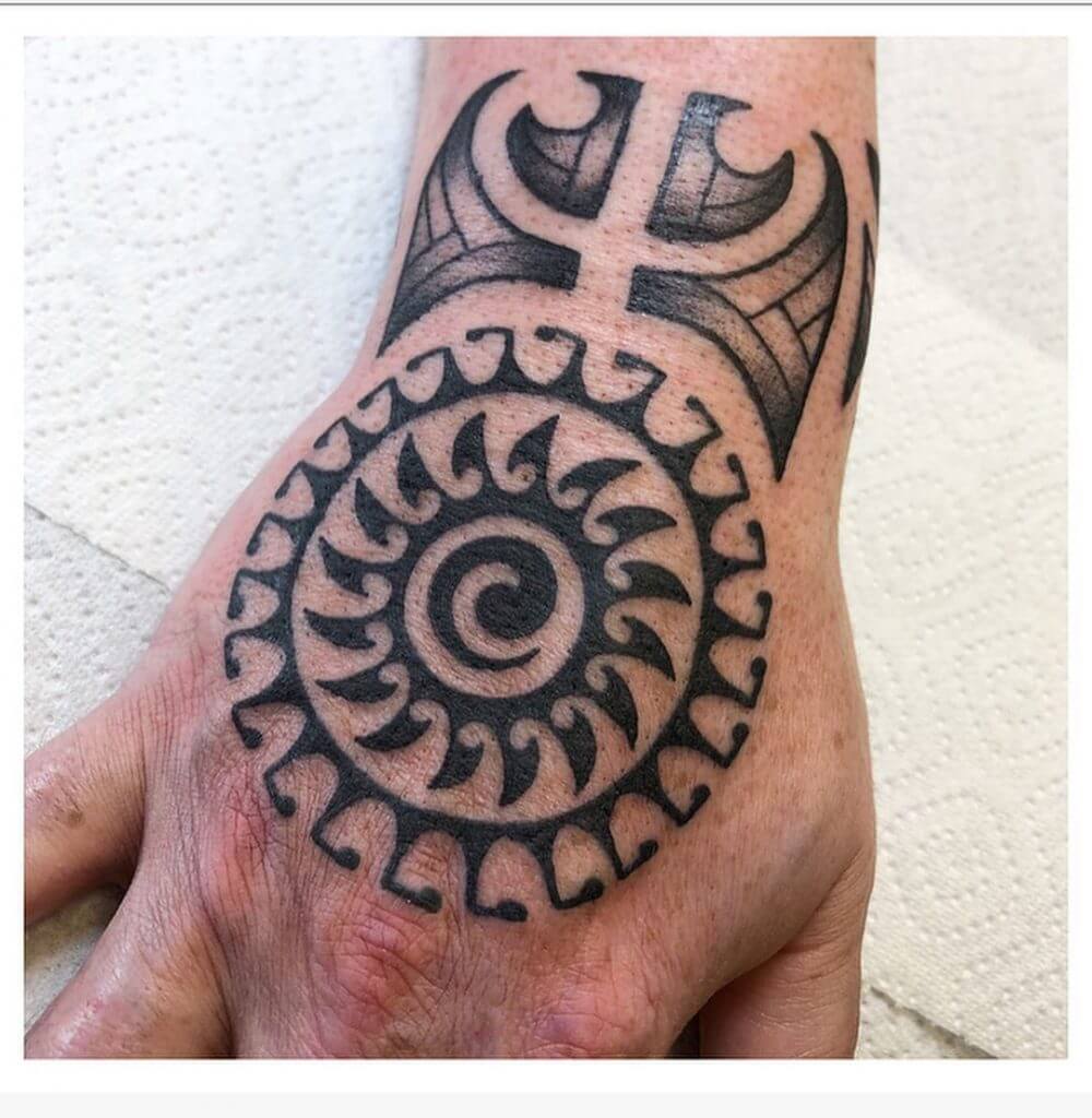 Tribal black sun tattoo on the right hand