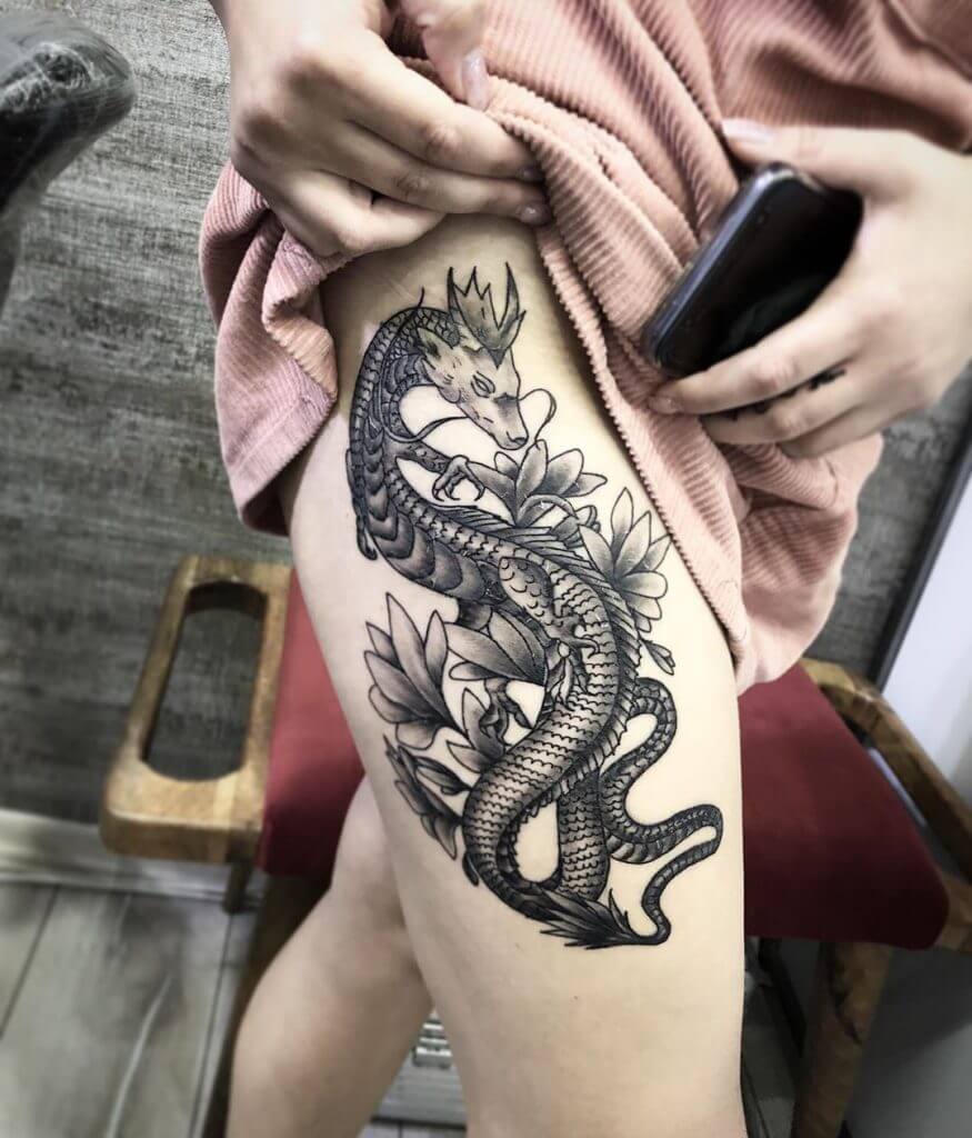 Black dragon tattoo for woman on the right thigh