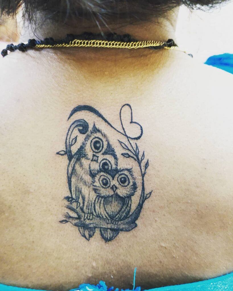 Black tattoo of two owls for women on the back