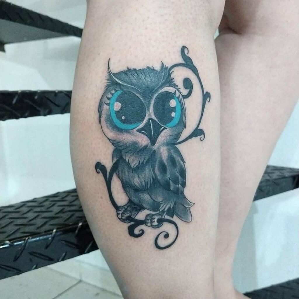 Black owl tattoo with blue eyes for women on the right calf
