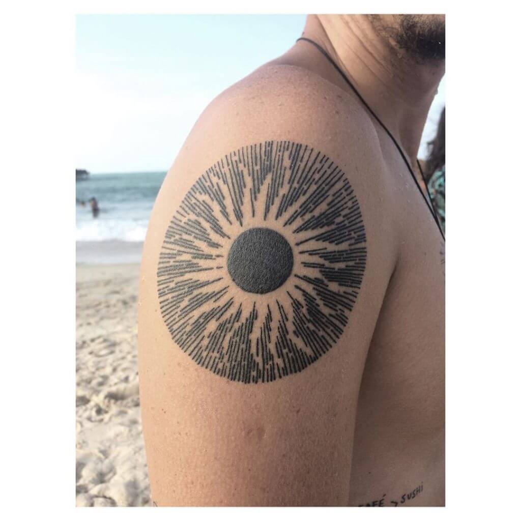 Black sun tattoo on the shoulder