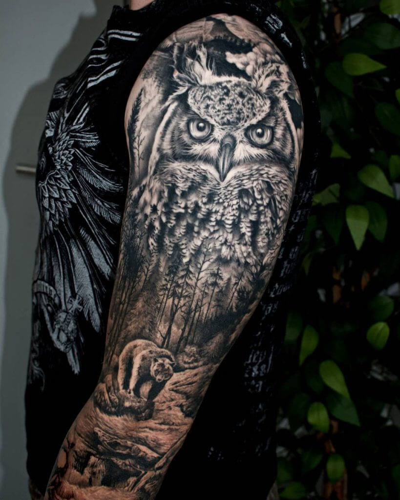 Black owl tattoo with a nature for men on the left arm