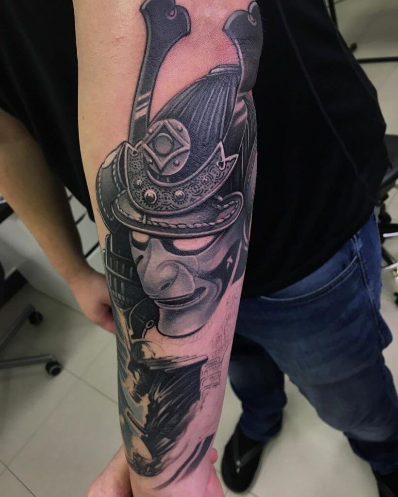 Black samurai mask tattoo on the forearm
