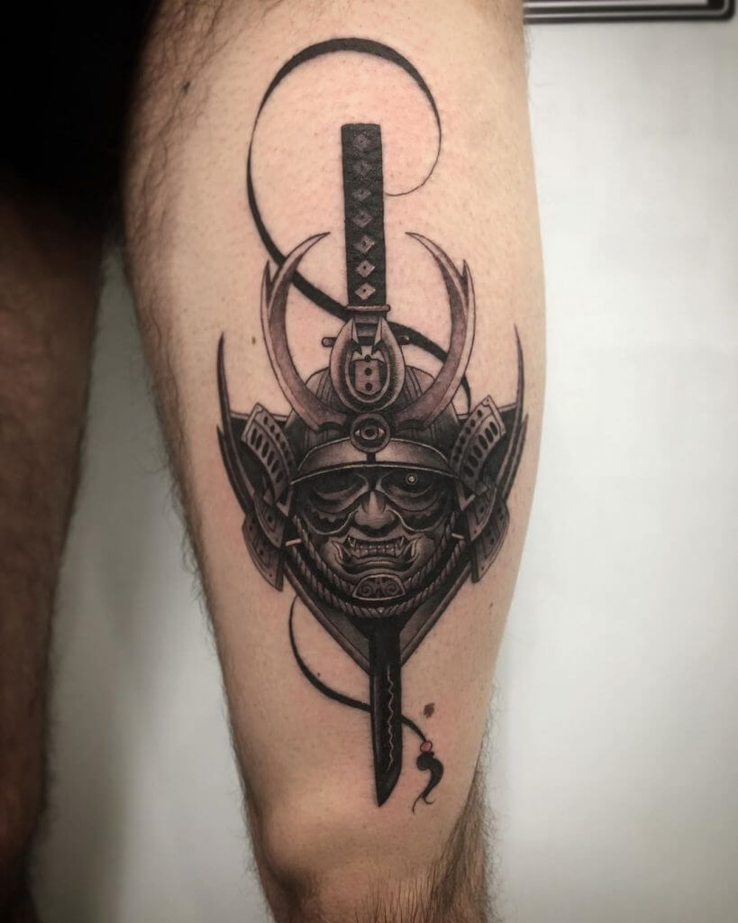 Black samurai mask tattoo on the thigh