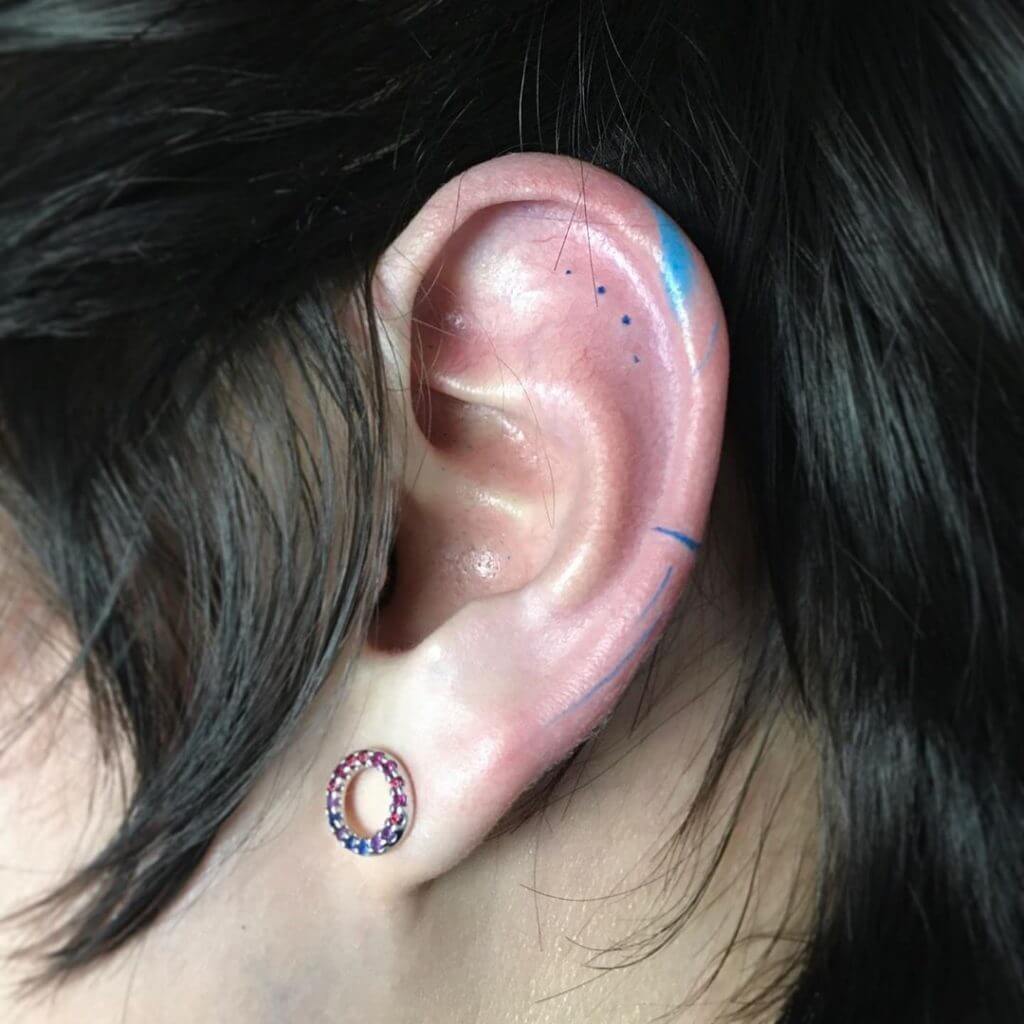 Small color abstract tattoo on the left ear