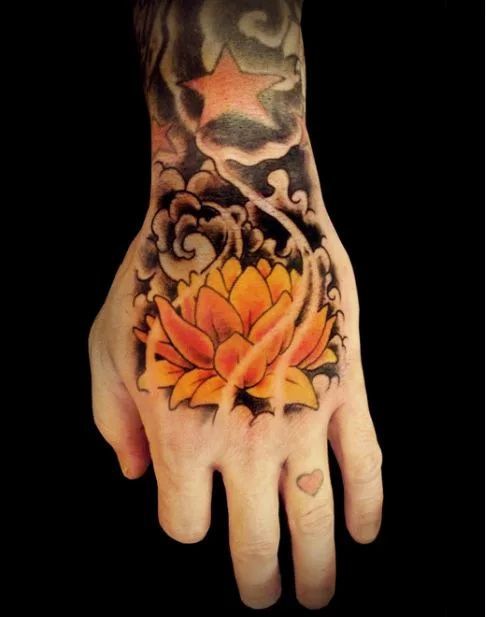 Yellow lotus tattoo on a top of the hand