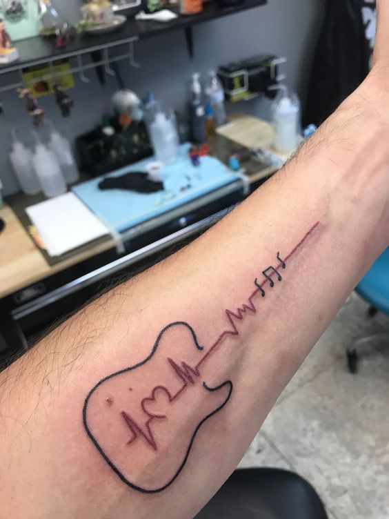 Forearm Heartbeat tattoo with musical notation scale