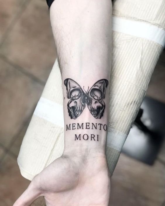 Forearm memento mori tattoo with a butterfly 