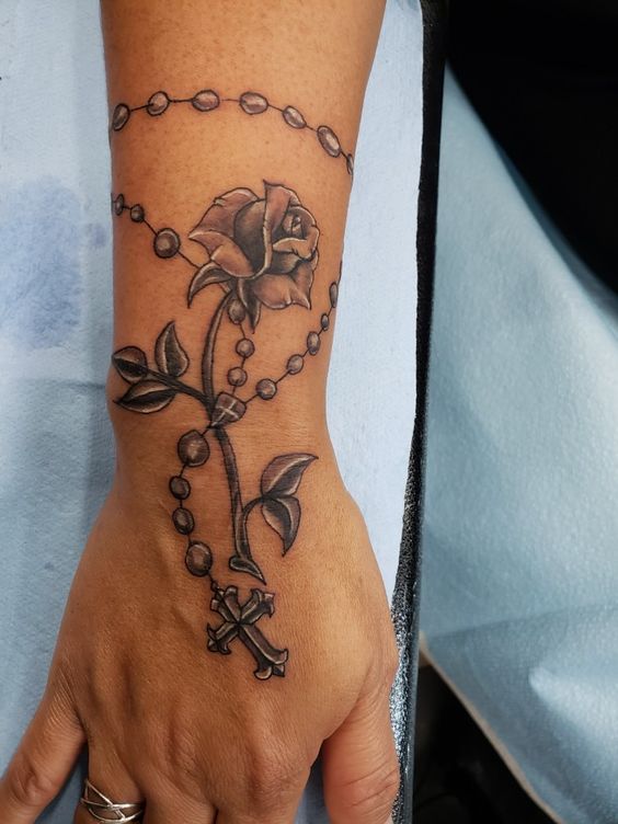 Wrist rosary tattoo with rose