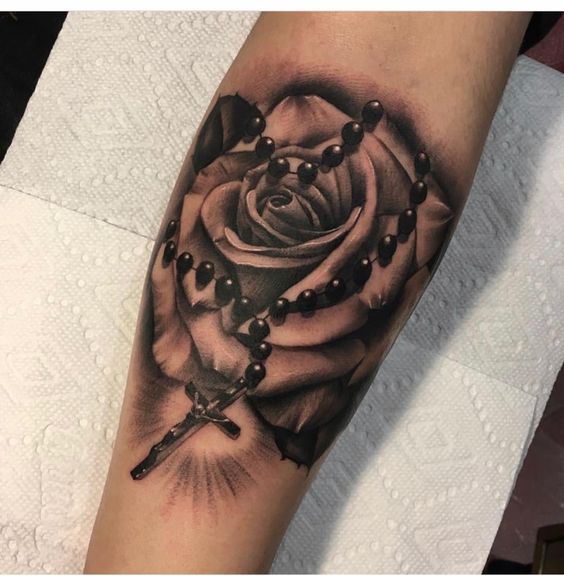 Forearm rosary tattoo with rose