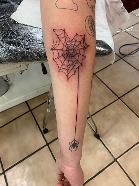 Forearm spider web tattoo with spider