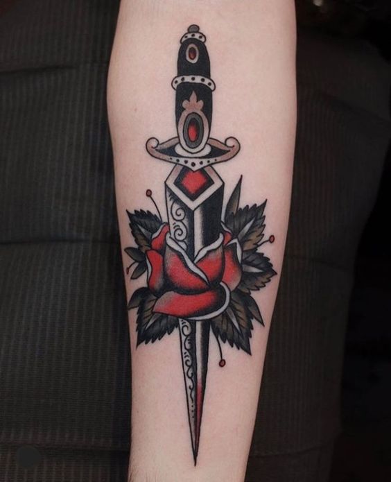 Forearm rose dagger tattoo