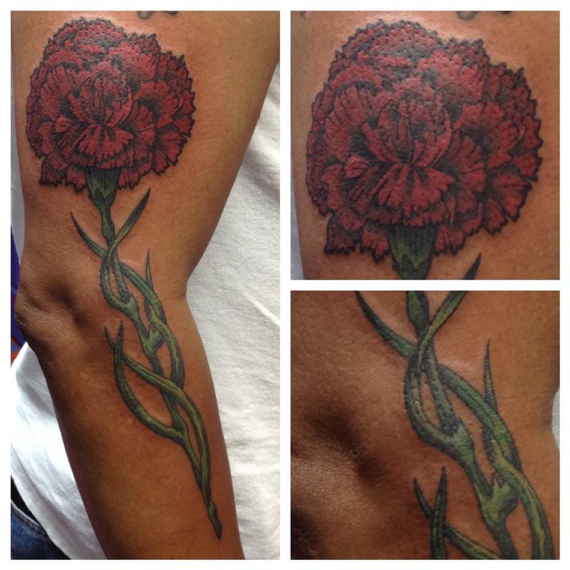 Dark red Carnation tattoo on the arm
