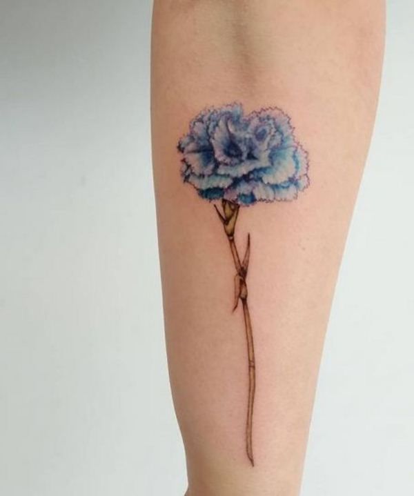 A blue forearm Carnation tattoo