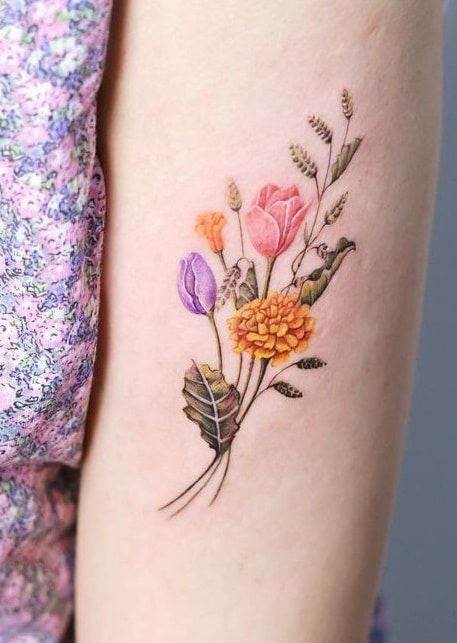 Arm Marigold tattoo with wild flowers