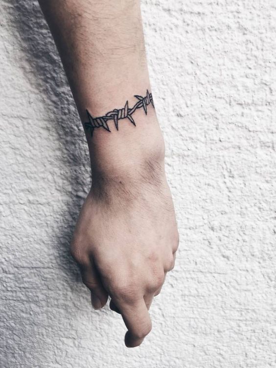 Bold wrist barbwire tattoo design symbolizing the duality of protection and restriction.