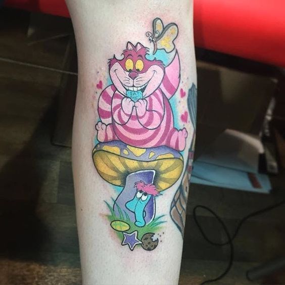 Cheshire cat tattoo with whimsical elements on forearm